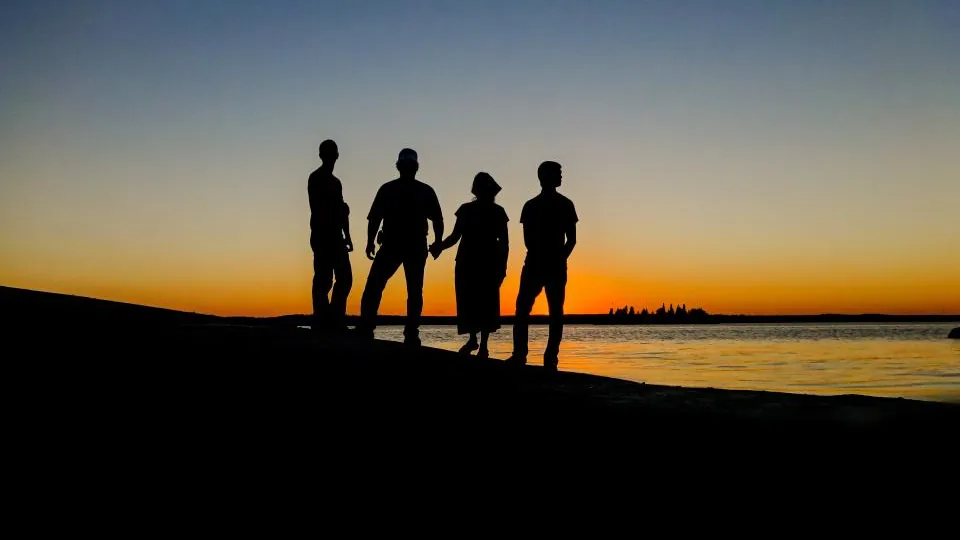 Silhueta de um grupo de pessoas ao pôr do sol